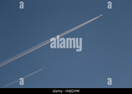 Passagierjet Flugzeug Kondensation Routen Con Wanderwege vor einem strahlend blauen Himmel Stockfoto