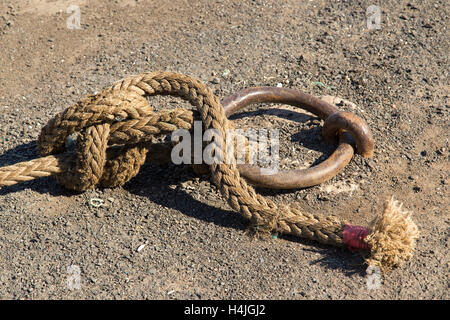 Nahaufnahme des Hanfseils des Schiffs, das um den Festungsring geknotet ist, mit einem Bowlinenknoten. Stockfoto