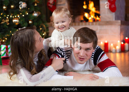 Weihnachten, Weihnachten, Familie, Menschen, Glück Konzept - glückliche Eltern mit hübschen Baby spielen Stockfoto