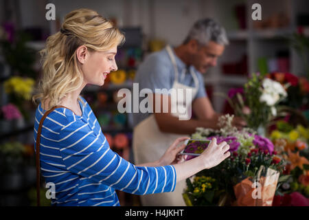 Frau nehmen Foto von Blumenstrauß Stockfoto