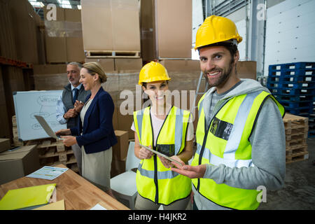 Lagerarbeiter im Lager zusammenstehen Stockfoto