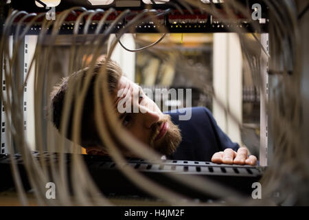 Techniker überprüfen Kabel in einem Rack montiert server Stockfoto