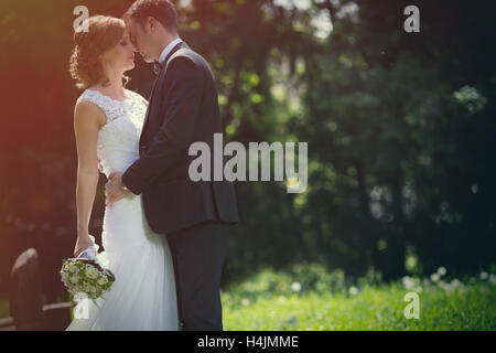 Schöne Braut und Bräutigam küssen im freien Stockfoto