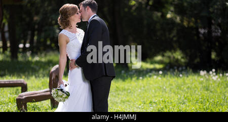 Schöne Braut und Bräutigam küssen im freien Stockfoto