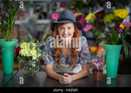 Glücklich weibliche Florist stützte sich im Blumenladen Stockfoto