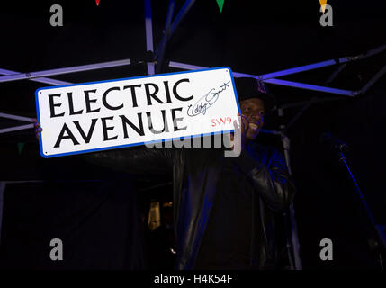 Brixton, UK. 17. Oktober 2016. Eddy Grant, Musiker, hält ein signiertes Electric Avenue Street zu unterzeichnen, da er den Schalter auf der neuen Lichter in der Electric Avenue Brixton nach einer kürzlichen Renovierung des Marktes Credit besucht: Keith Larby/Alamy Live News Stockfoto