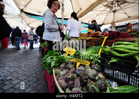 Eine Frau kauft ihre Lebensmittel an eine pflanzliche Stand der Morgenmarkt Campo dei Fiori in Rom, Italien Stockfoto