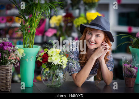 Glücklich weibliche Florist stützte sich im Blumenladen Stockfoto