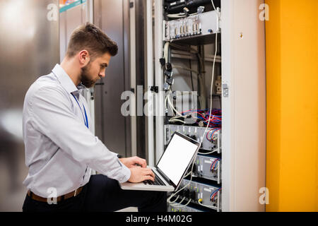 Techniker mit Laptop während der Analyse der server Stockfoto