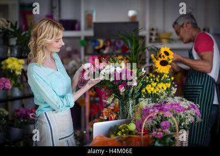 Floristen Sprühwasser auf Blumen im Blumenladen Stockfoto