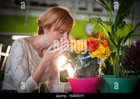 Weibliche Florist duftende Rosenblüten Stockfoto