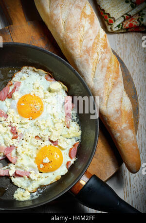 Spiegeleier in einer Pfanne mit Brot zum Frühstück Stockfoto