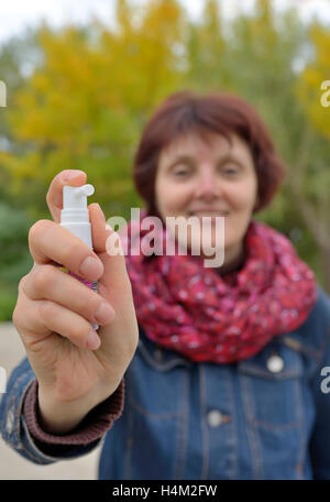 Frau mit Hals-Spray in der kalten Jahreszeit Stockfoto