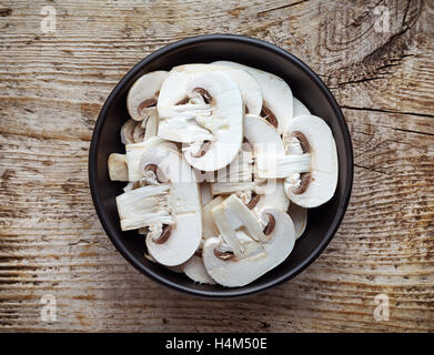 Schüssel mit in Scheiben geschnittenen frischen Pilz auf Holztisch, Ansicht von oben Stockfoto