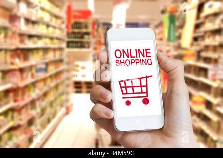 Online-shopping-Anwendung auf dem Handy-Bildschirm mit Lebensmittelgeschäft im Hintergrund Stockfoto