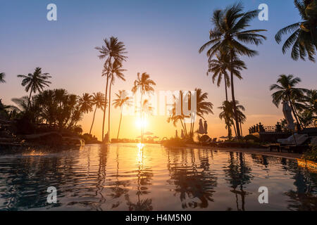 Luxury Beach Hotel, Silhouette mit Palmen, Pool, ein schöner Sonnenuntergang Stockfoto