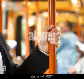 Person Holding Handgriff. ÖPNV-Interieur Stockfoto