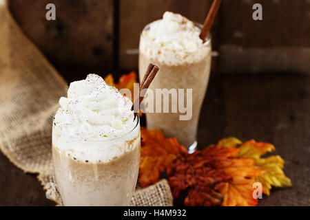 Pumpkin Spice Eiskaffee mit Sahne und Zimt vor einem rustikalen Hintergrund. Geringe Schärfentiefe. Stockfoto