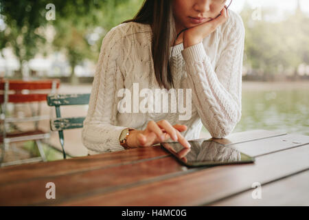 Junge Frau mit digital-Tablette am Café im Freien. Weibliches Browsen Webseiten auf dem Touch-pad im Coffee-Shop. Stockfoto