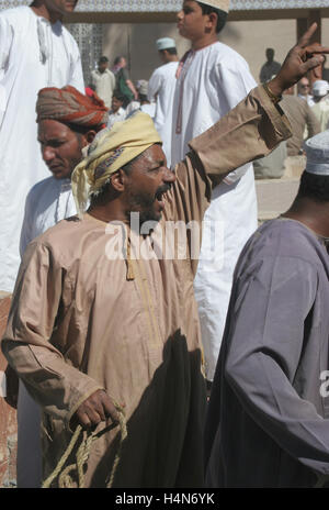 Eine lokale Stammesangehörige Gebote für das Vieh auf den berühmten Viehmarkt in Nizwa, der alten Hauptstadt von Oman Stockfoto