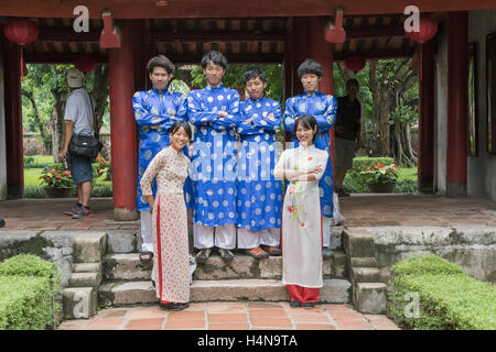 Touristen, die verkleidet um zu posieren in einem Innenhof am Tempel des Konfuzius, Hanoi, Vietnam Stockfoto