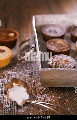Schokolade Mini-Törtchen in Vintage Alu Backen Pfanne mit Zucker bestäuben Stockfoto