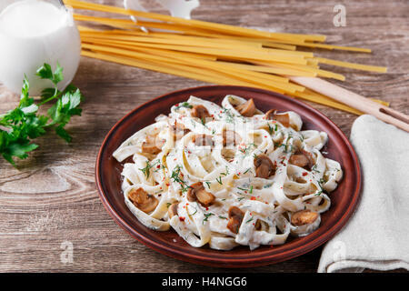 Nudeln mit Käse und gebratenen Pilzen in weißer Soße Stockfoto