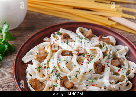 Nudeln mit Käse und gebratenen Pilzen in weißer Soße Stockfoto