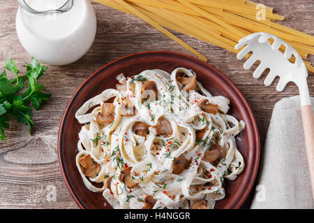 Nudeln mit Käse und gebratenen Pilzen in weißer Soße Stockfoto