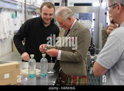 Der Prince Of Wales, bekannt als der Herr der Inseln während auf den westlichen Inseln, bringt einem das Etikett einer Weinflasche Gin bei einem Besuch auf der Insel Harris Brennerei, eröffnete er offiziell in Tarbert auf der Isle of Harris. Stockfoto