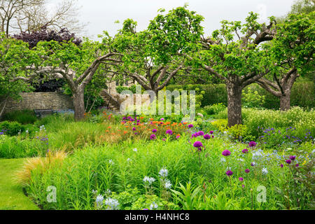 Blick über einen Garten mit Blumenbeeten und Bäumen in Oxfordshire. Stockfoto