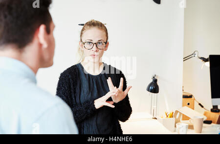 Eine Frau, Gespräch mit einem Mann im Amt. Stockfoto