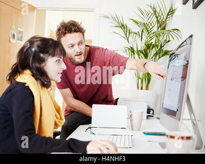 Zwei Personen zusammen arbeiten, im Büro, einem Computer-Bildschirm betrachten. Stockfoto