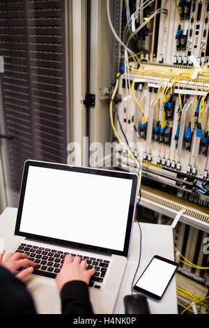 Techniker mit Laptop während der Analyse der server Stockfoto