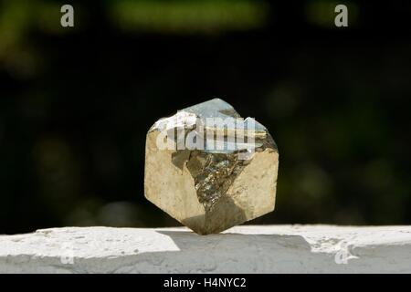 Pyrit Würfel auf weiße Wand mit dunklem Hintergrund Stockfoto