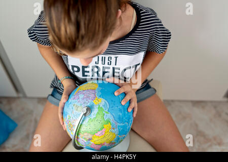 Elche, Spanien. 10. September 2016: Teenager mit dem Ball der Welt auf der Suche nach Orten. vertikale zu erfassen. Stockfoto