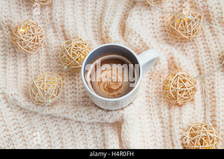 Heiße Schokolade Tasse mit wollene Pullover und Lichter Dekoration Stockfoto