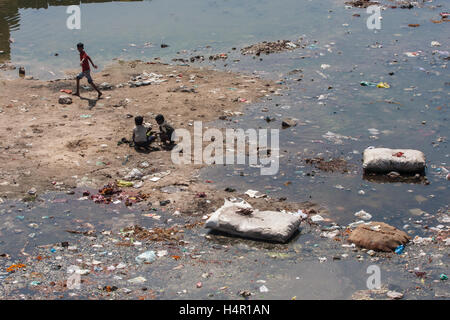 Kinder spielen in dreckigen und verschmutzten Fluss Sabarmati in das Zentrum von Ahmedabad, Gujarat Zustand, Indien, Asien. Stockfoto