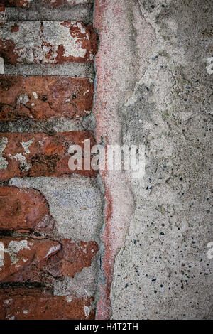 Antike Wand mit roten alten Ziegeln und Schichten von Gips in Toulouse, Frankreich, Nahaufnahme. Grunge Hintergrund. Stockfoto