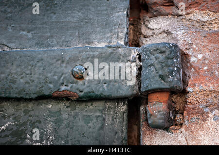 Detail des antiken Metalltor mit Scharnier und alte Mauer. Toulouse, Frankreich. Stockfoto