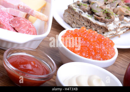 Nudeln mit Wurst und Squash Kaviar auf Platte. Mayonnaise und Pilz Salat Stockfoto