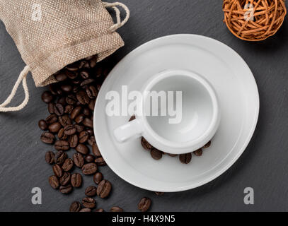 Heap-Kaffee-Bohnen und eine Tasse frischen Kaffee Stockfoto