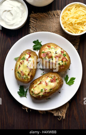 Hausgemachte Kartoffelschalen mit Speck, Käse und grüne Zwiebel, Ansicht von oben Stockfoto