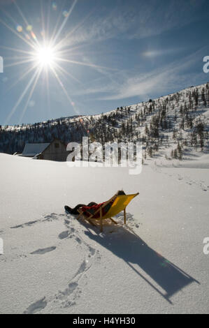 Ein Sonnenbad im Liegestuhl im Schnee, Woerschach, Steiermark, Österreich, Europa Stockfoto