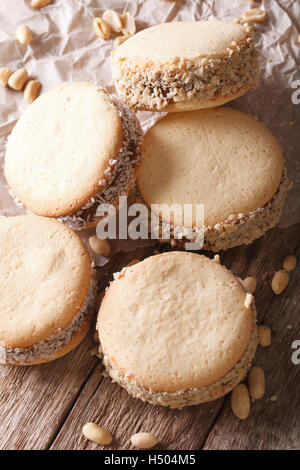 Alfajores hausgemachte Kekse mit Kokos und Erdnüsse Nahaufnahme auf dem Tisch. vertikale Stockfoto