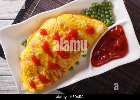 Japanische Omelette gefüllt mit Reis und Huhn Nahaufnahme auf einer Platte. Horizontale Ansicht von oben Stockfoto