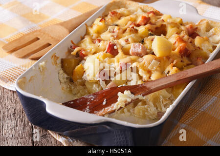 Ofenkartoffel mit Speck und Käse hautnah in Auflaufform legen. horizontale Stockfoto