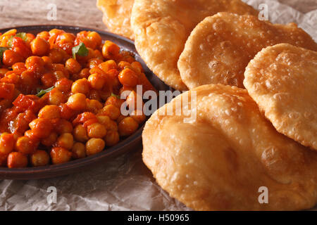 Indisches Brot Puri und Chana Masala Makro auf dem Tisch. Horizontale Stockfoto