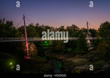 Brücke über den Fluss Reedy in der Dämmerung, bei Falls Park auf die Reedy, in Greenville, South Carolina. Stockfoto