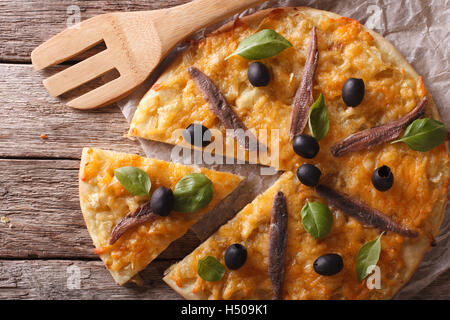 In Scheiben geschnittene Pizza mit Sardellen und Zwiebeln Nahaufnahme auf dem Tisch. horizontale Ansicht von oben Stockfoto